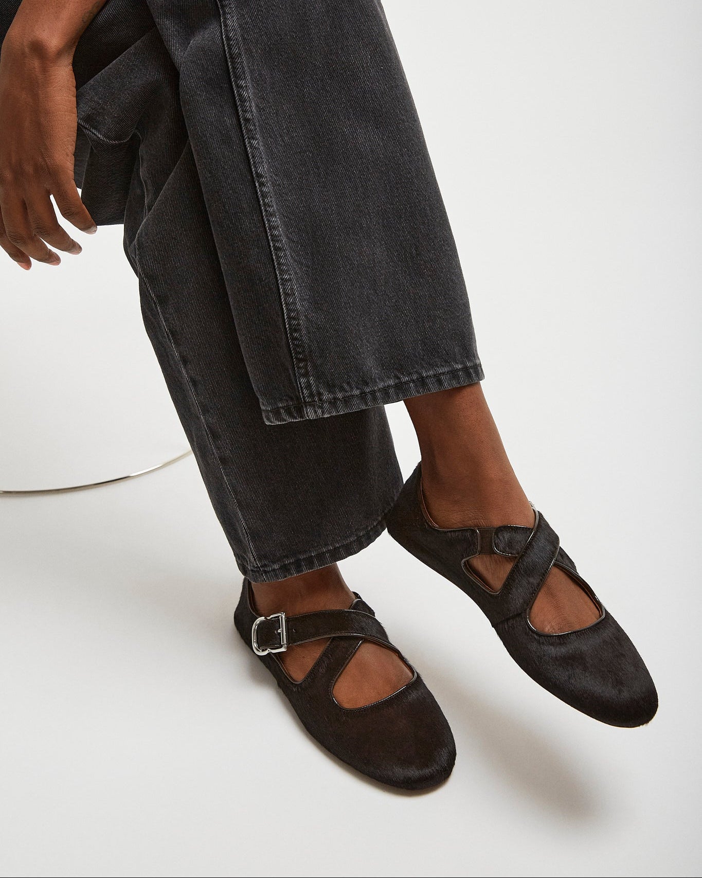 Person wearing black shoes and jeans on a white background