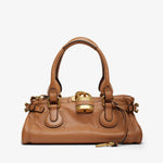 Brown handbag with gold accents on a white background