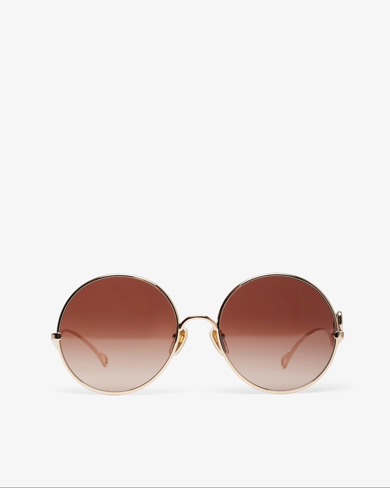 Round sunglasses with a gradient brown lens on a white background