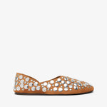 Tan flat shoe with white embellishments on a white background