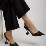 Person wearing black high-heeled shoes with a white background