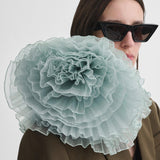 Person wearing a large light blue floral accessory on a white background