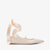 Beige ballerina shoes with ribbon straps on a white background
