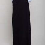 Person wearing a light blue shirt and black long skirt on a plain background