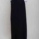 Person wearing a light blue shirt and black long skirt on a plain background